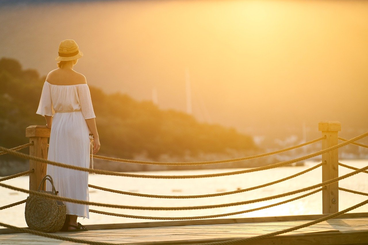 Woman with healthy boundaries watching the sunset on a bridge
