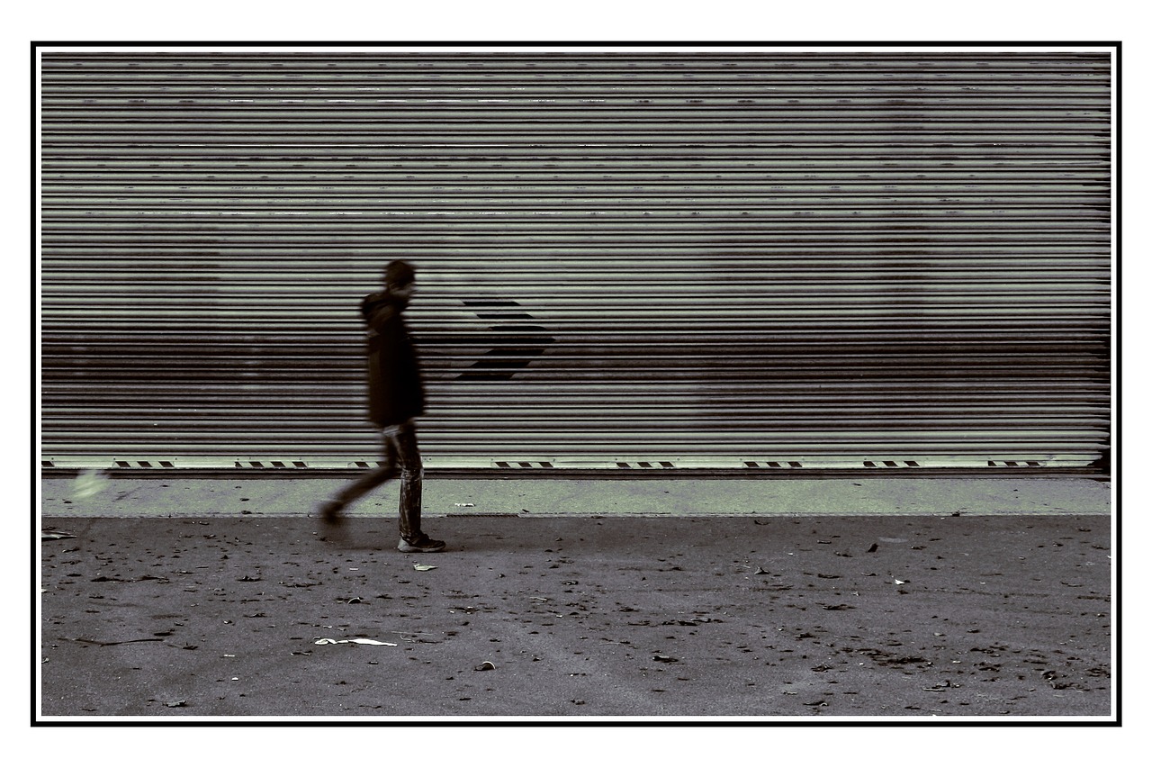 Person, experiencing a burnout, walking past a grey wall