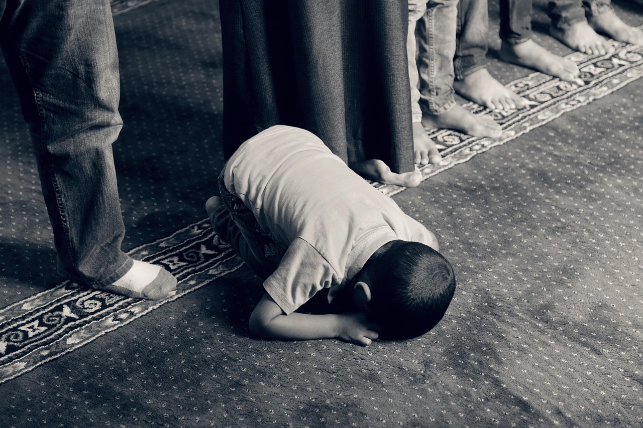 Kid praying on the ground. Spirituality can be found in religion